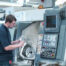 Man holds CNC lathe: DNC and CMMS software