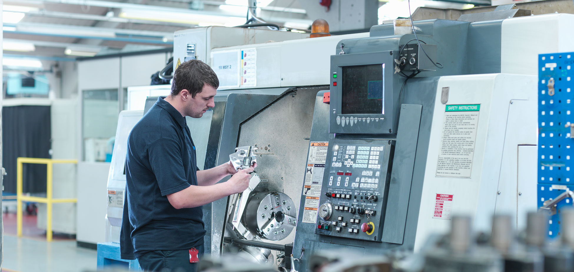Man holds CNC lathe: DNC and CMMS software
